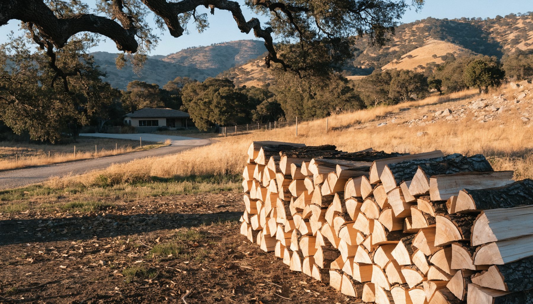 A neatly stacked cord of split oak firewood in the dry golden hills of Santa Barbara County